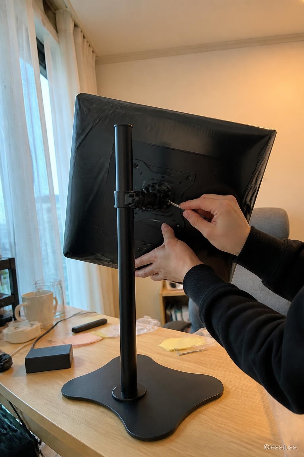 모니터 뒷면을 VESA 판에 나사로 고정하는 모습